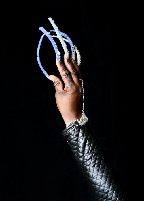 Black woman's hand with very long painted finger nails and jewelry