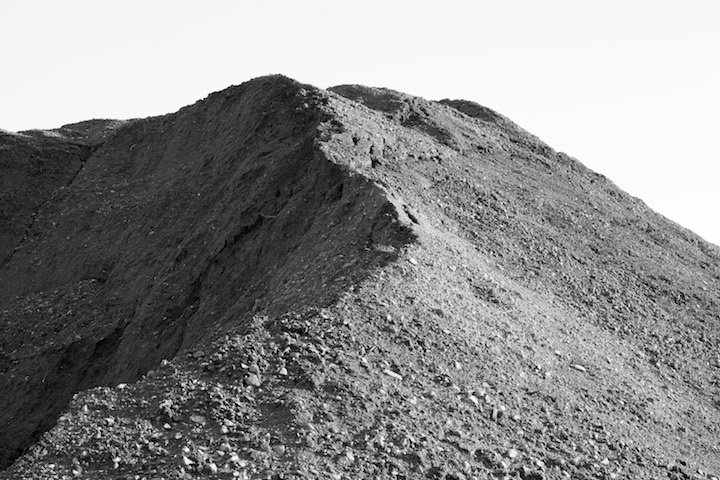Black and white photograph of a mound of dirt