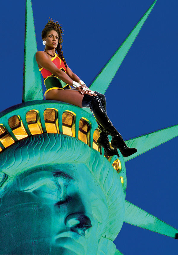 A Black woman in a super hero outfit sits on the statue of liberty's crown